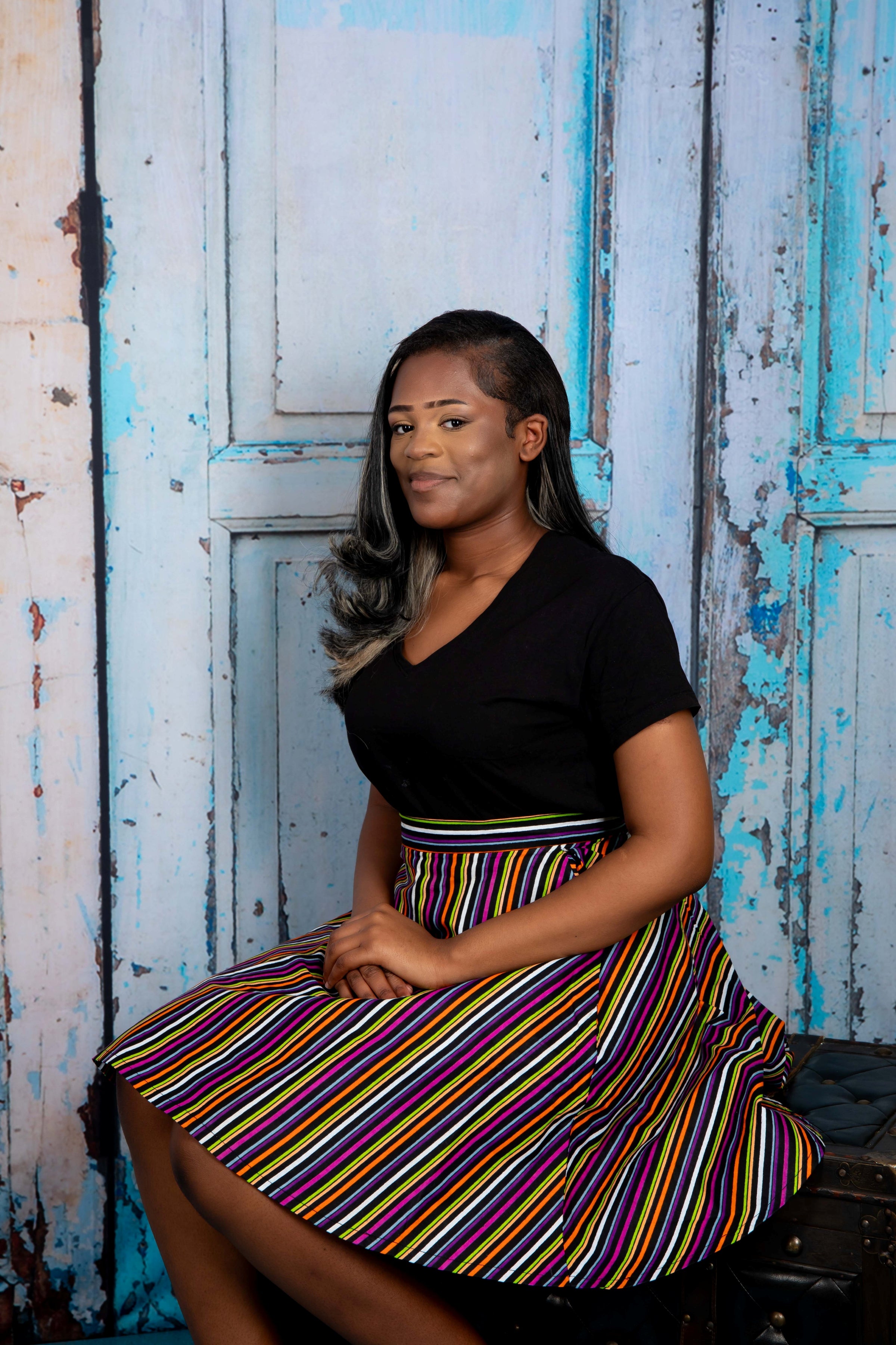Mini circle skirt with vibrant stripy African print fabric, featuring bold, multicolored horizontal and vertical stripes. Chic mini circle skirt in bold, stripy African print—featuring vibrant multicolor patterns and a playful, flared silhouette perfect for standout styling